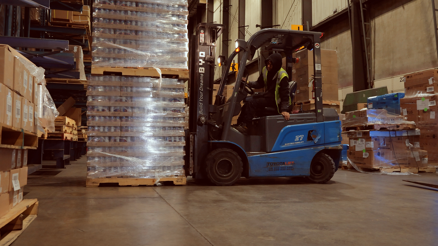 A forklift operator moving a pallet of product